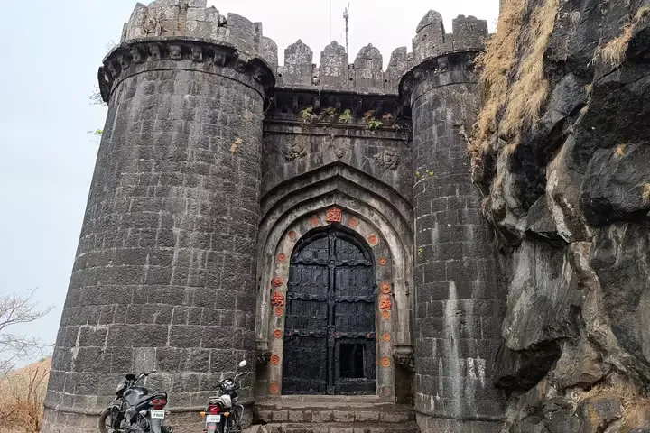 The black stone main gate of Ajinkyatara Fort flanked by two massive circular bastions