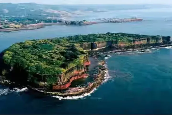 Aerial view of the forested island of Suvarnadurg sea fort ringed by cliffs and the Arabian Sea off the Harnai coast